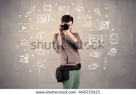 An amateur hobby photographer learning to use a professional digital camera with camera settings icons on the background wall concept