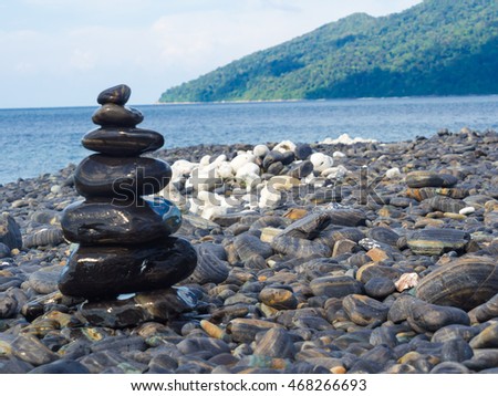 Black stones Lipe beach mountain background, Thailand