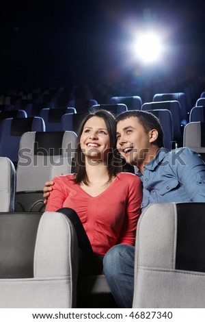 Enamoured laughing couple at a cinema on a forward background Royalty-Free Stock Photo #46827340