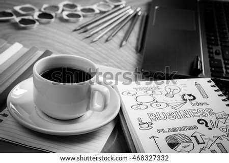 Work table with cup of coffee, goal of business illustration on sketch book, folders & laptop / business background conceptual