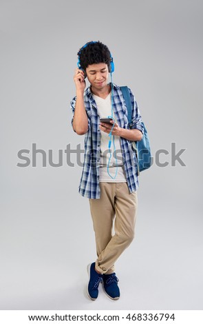 Happy smiling mixed race man choosing a song playlist on his mobile cell phone