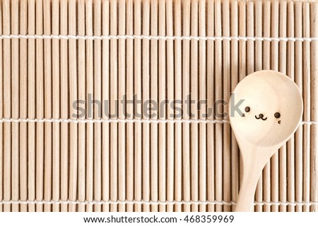 Cute wooden spoon on Bamboo stick straw mat texture for background