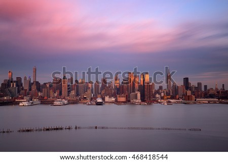 Midtown skyline over Hudson River in New York City with skyscrapers at sunset