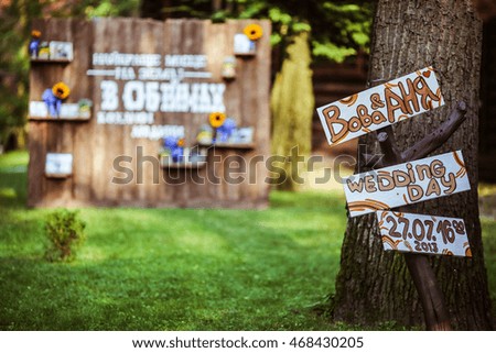 Boards with wedding letterings stand behind an old tree
