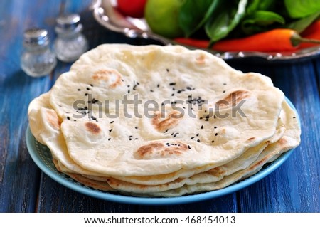 Homemade bread pita bread on a blue background.