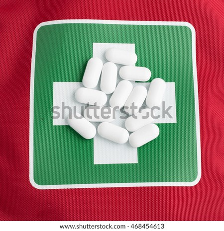 White pills on a medical red green kit