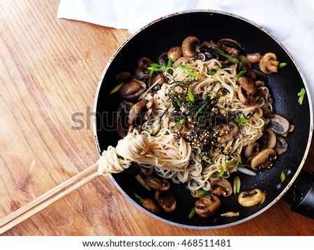 Healthy vegetarian Japanese lunch; Somen (fine soba) with skillet champignon in tsuyu sauce and mixed Japanese premium seaweed serve in a hot pan. Spring grilled black and white sesame before serve. Royalty-Free Stock Photo #468511481