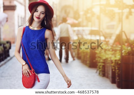 Outdoor portrait of young beautiful happy smiling woman posing on street. Model wearing stylish hat and clothes. Girl looking at camera. Female fashion. Sunny day. City lifestyle. Copy space for text Royalty-Free Stock Photo #468537578