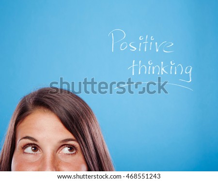 Portrait of a beautiful young woman on a blue background is thinking positive.