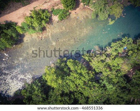 Aerial view Barton Creek in Greenbelt area, a 7.9 miles long with 809 acres begins at Zilker Park. It has sheer limestone cliff, lush trees. People swimming , canoe and kayak in cold natural water.