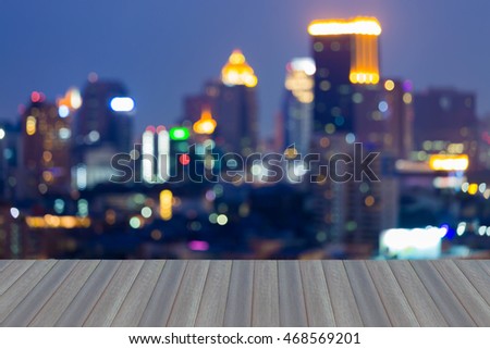 Opening wooden floor, abstract blurred lights urban office building at twilights 