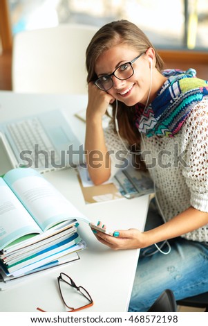 Young woman sitting at a desk among books