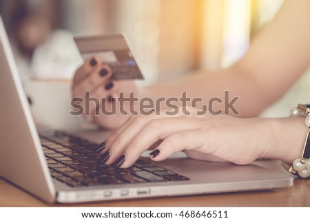 Online payment,Woman's hands holding a credit card and using smart phone for online shopping with vintage filter effect