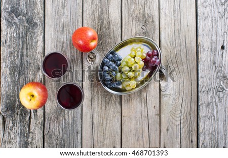 glasses of wine and apples, grapes on old wooden table