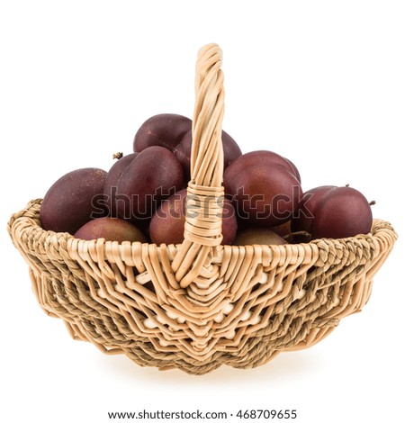 Sweet Plums in the wicker basket isolated on white background. Selective focus.