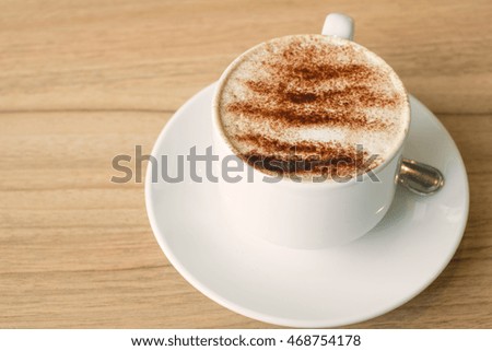 hot capucino on wood table, vintage effect