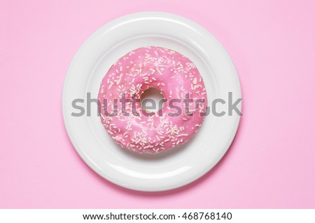 Donut covered with icing in plate, top view. Photo in a pink color scheme Royalty-Free Stock Photo #468768140