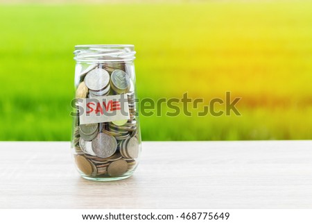 money in the glass on flare and green background.