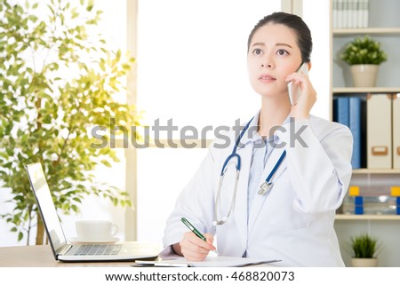 Doctor explain patient's condition by smart phone and computer, health care and medicine concept, hospital office background