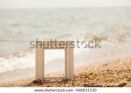 Photo frame on sand beach