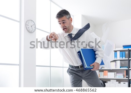 Stressed anxious businessman in a hurry checking time and running, he is late for his business appointment Royalty-Free Stock Photo #468865562