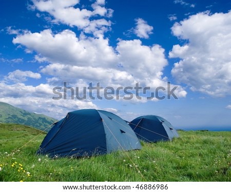 two touristic tents in a field