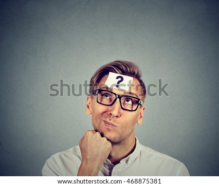 thinking man with question mark on gray wall background