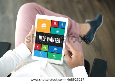 People using tablet pc in office and HELP WANTED icons concept on screen