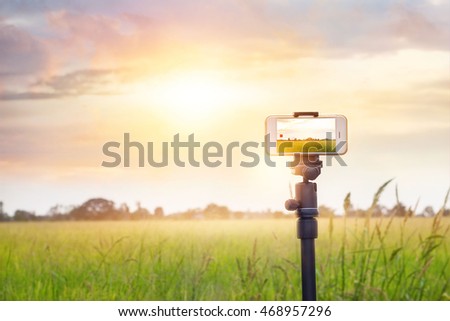 
Smartphone on tripod record timelapse in the sunset nature background