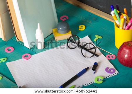 Back to school stationery is on the table. Chalkboard background