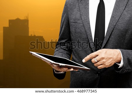 business man holding computer tablet selective focus on pointing finger with city light background