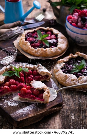 Blueberry,cherry,raspberry and blackcurrant galette on wooden background.