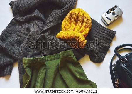 Brown wool cardigan, green corduroy skirt, a yellow hat and a handbag. Photo of fashionable women's clothing combinations. Fashion blogger outfit. Flat lay, top view