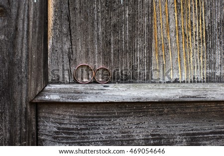 Two wedding rings on gray wood background. Vintage filter.