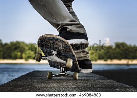 young skateboarder doing trick on blue sky background