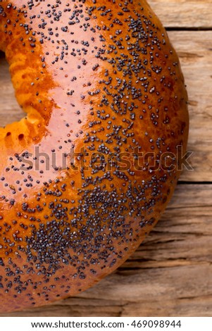 Freshly baked bread with poppy seeds on a wooden background.