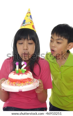 Image of children  blowing on the candles placed in the cake