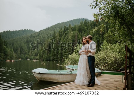 Vintage wedding photography of a young hipster couple curly bride posing at sunset in the forest and mountains dressed in a suite and white dress 

