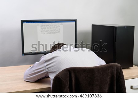 male writer (worker) fall asleep in front of computer - stock photo