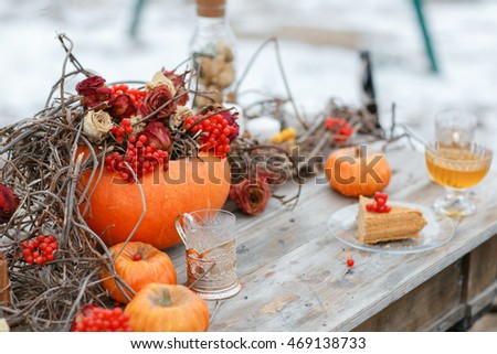 halloween inspiration. Autumn still life. pumpkin, dry roses, viburnum honey cake. in a vase. twigs. on the table