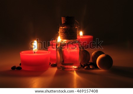 spa composition. scented candles, coffee beans, aromatic wooden balls and oil in a glass jug with a stopper. Photo executed in a dark key. partially tinted photo.