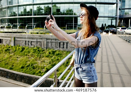 Travel sightseeing wander hobby recreation concept. Outdoor summer smiling lifestyle portrait of pretty young woman having fun in the city with camera. Photographer making pictures