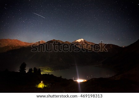 Shooting star at night sky in the mountain camp near Big Almaty Lake in Kazakhstan