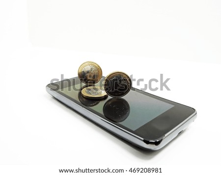 Smartphone on white background with some coins