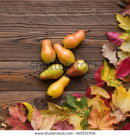 pears scattered with fallen leaves on wooden table