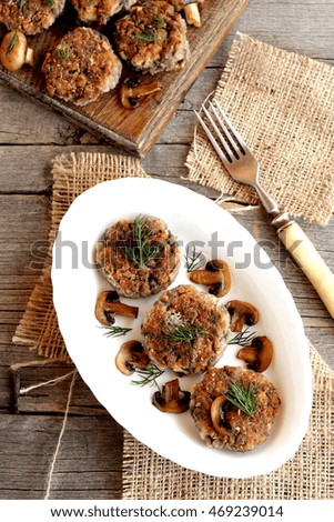 Delicious fried mushroom cutlets on a plate, fork, wooden table. Vegetarian cutlets cooked from mushrooms, onions, eggs, salt, spices and flour. Homemade food 