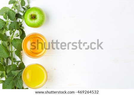 A detox food and healthy energy funny lifestyle concept: A set of healthy sweet tasty green and orange fruits and juice for funny party. Top view. On the white wooden background. Free space layout.
