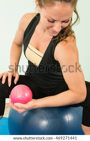 Exercising biceps with fitness ball and weights