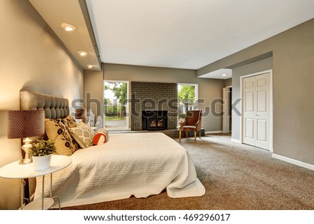 Spacious bathroom interior with brick fireplace and and white bedding. Also carpet floor. Northwest, USA