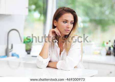 Picture of young sad woman in the kitchen